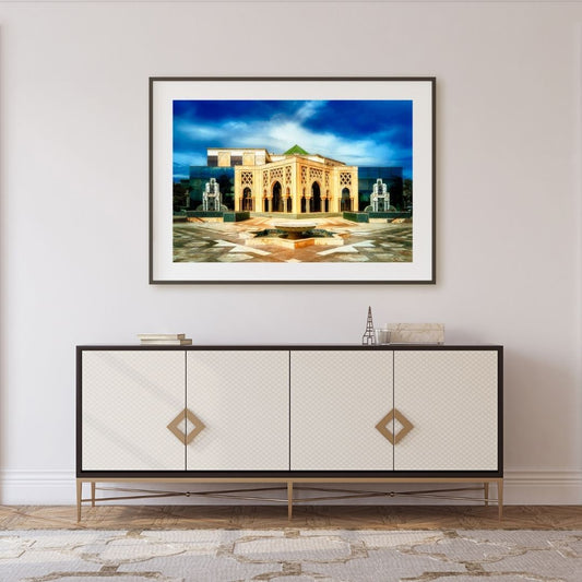 Framed artwork of a building on a wall above a decorative cabinet.
