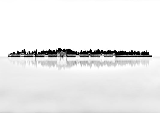 Black and white minimalist photograph of San Michele cemetery island in Venice, reflected in still water with architectural detail and cypress trees.