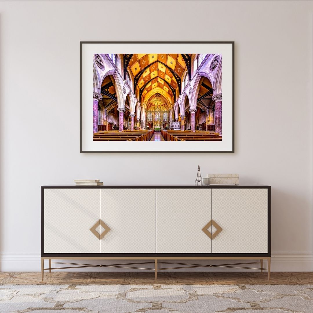 Framed artwork of a church interior above a decorative cabinet.