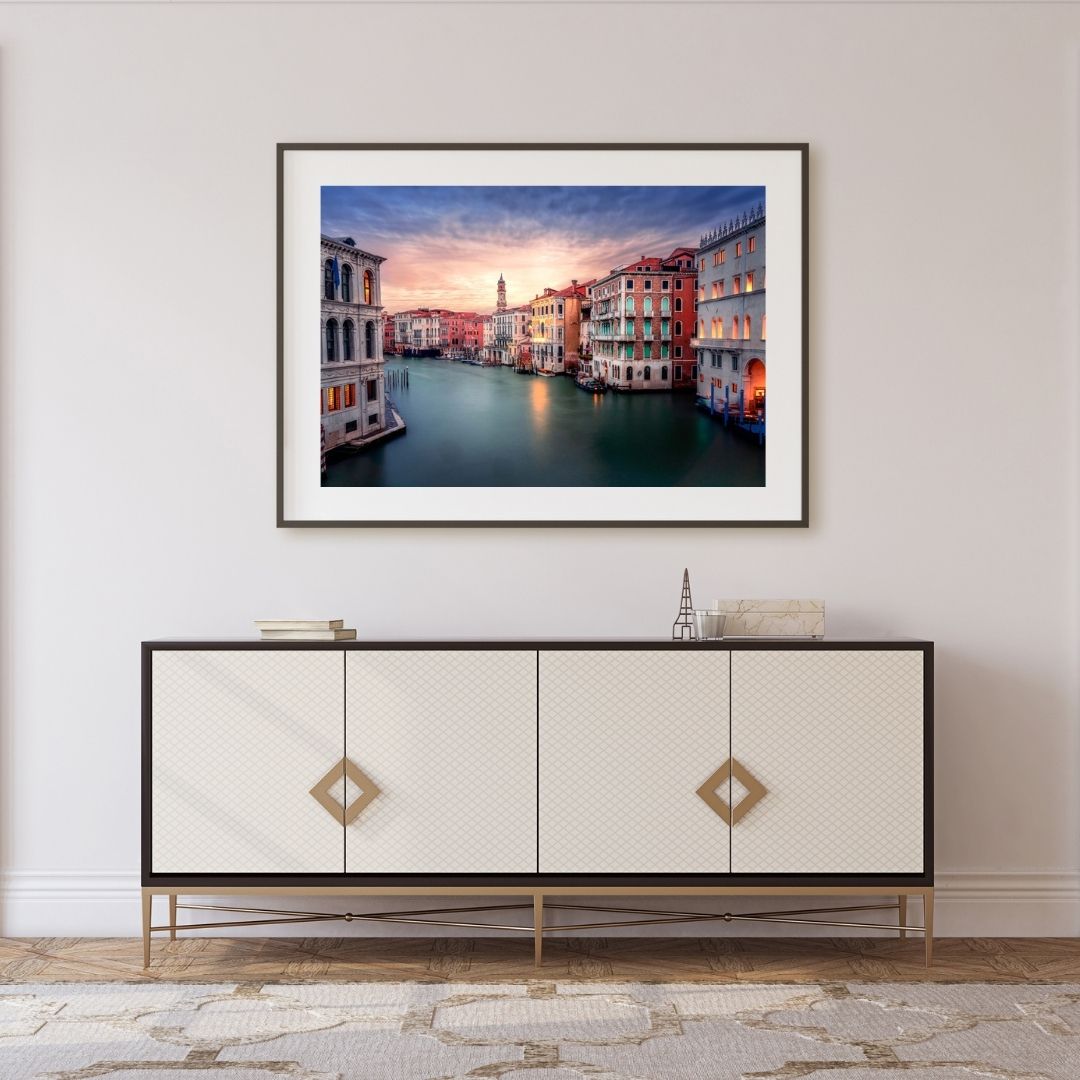 Framed artwork of Venice cityscape above a decorative cabinet.