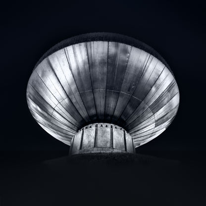 Black and white photograph of a Kyiv monument viewed from below emphasising circular form and dramatic structure