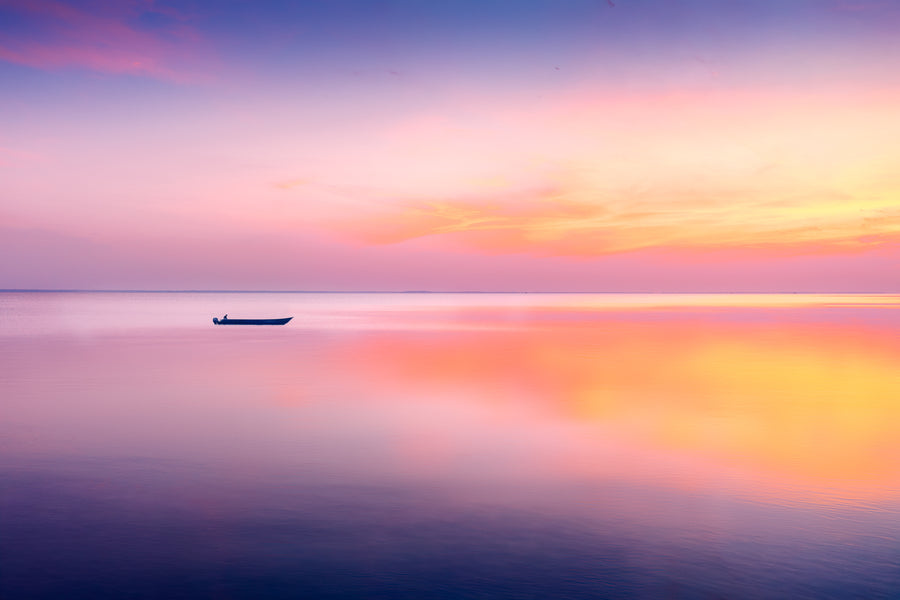 A fine art photograph near Kyiv, Ukraine, showing a small boat on still water at sunrise with soft pastel light and calm reflections.