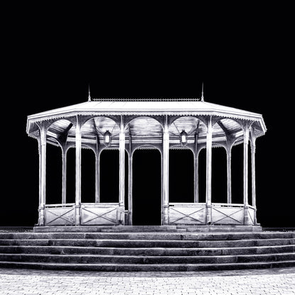 A fine art black and white photograph from Kyiv, Ukraine, showing a viewing pavilion illuminated at night against a dark sky.