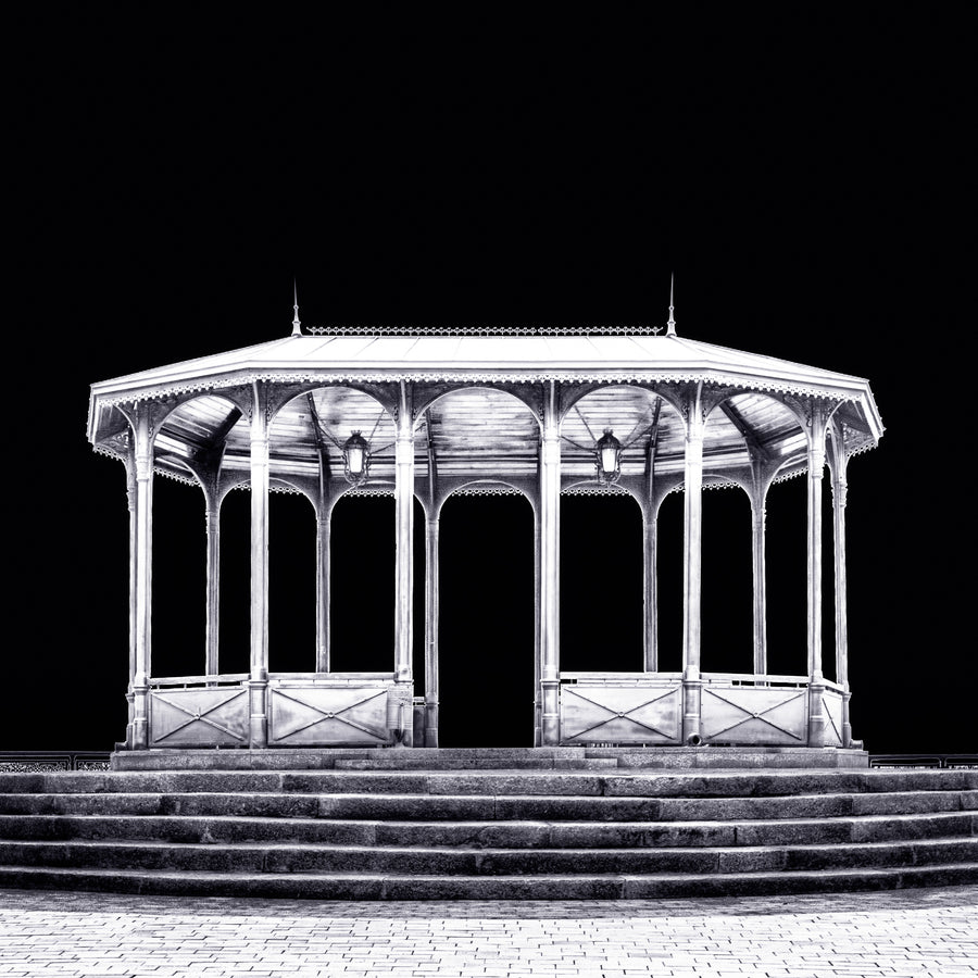 A fine art black and white photograph from Kyiv, Ukraine, showing a viewing pavilion illuminated at night against a dark sky.