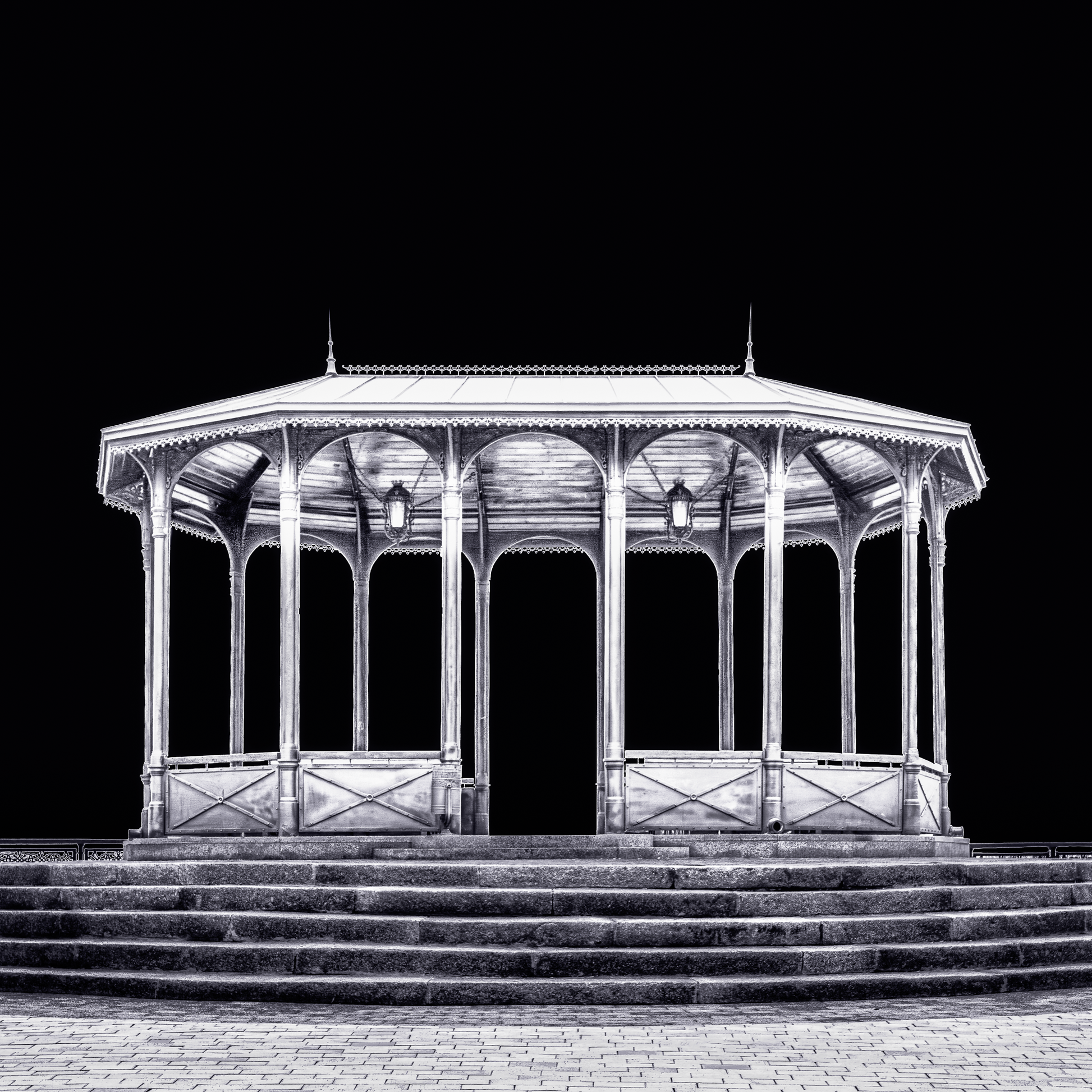 A fine art black and white photograph from Kyiv, Ukraine, showing a viewing pavilion illuminated at night against a dark sky.
