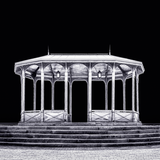 A fine art black and white photograph from Kyiv, Ukraine, showing a viewing pavilion illuminated at night against a dark sky.