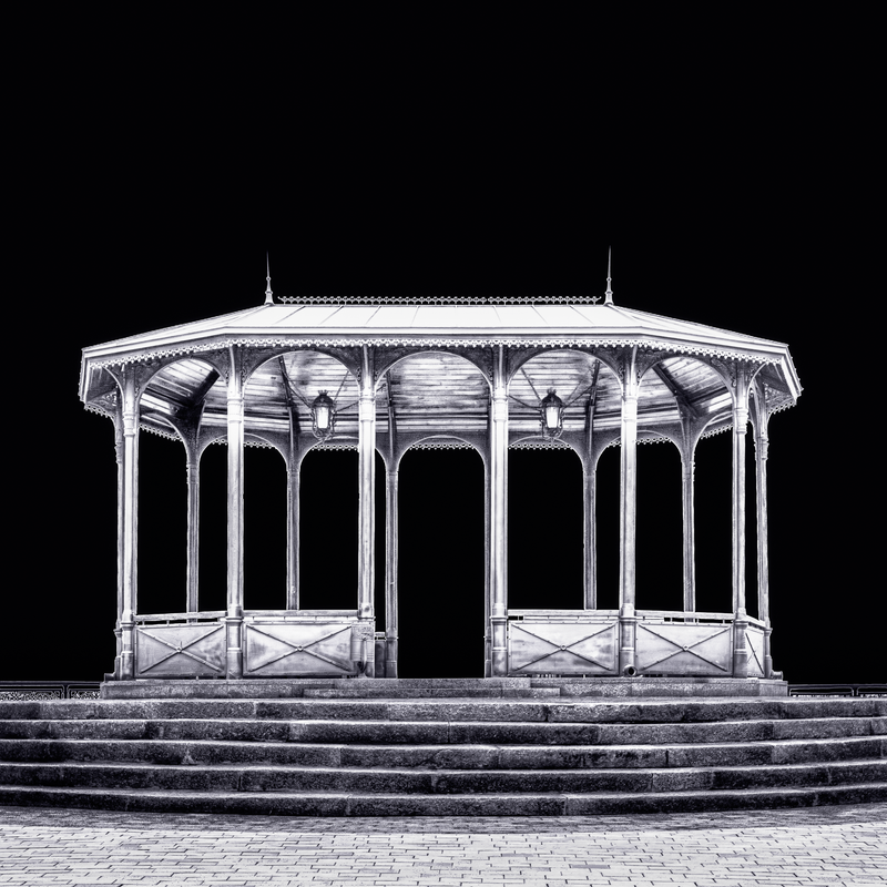A fine art black and white photograph from Kyiv, Ukraine, showing a viewing pavilion illuminated at night against a dark sky.