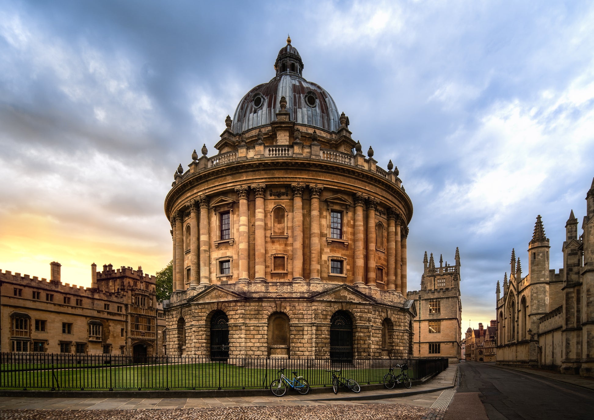 Colour photograph of the Radcliffe Camera in Oxford at sunset with warm stone architecture and dramatic evening sky.