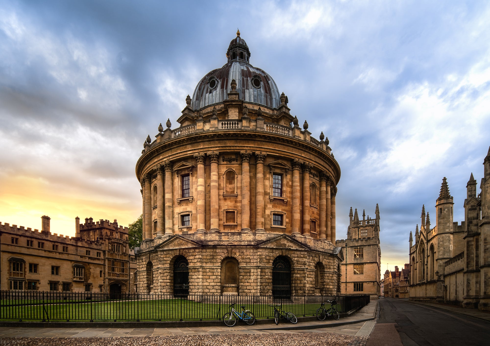 Colour photograph of the Radcliffe Camera in Oxford at sunset with warm stone architecture and dramatic evening sky.