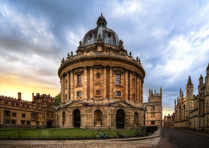 Colour photograph of the Radcliffe Camera in Oxford at sunset with warm stone architecture and dramatic evening sky.