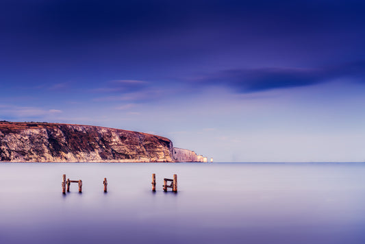 Fine art long exposure photograph of Swanage old pier with Purbeck cliffs in the background, Dorset coast, UK.