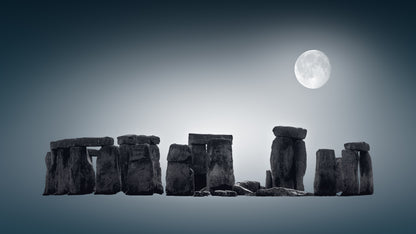 A fine art black and white photograph of Stonehenge in Wiltshire, England, with the full moon above the ancient stones at night.
